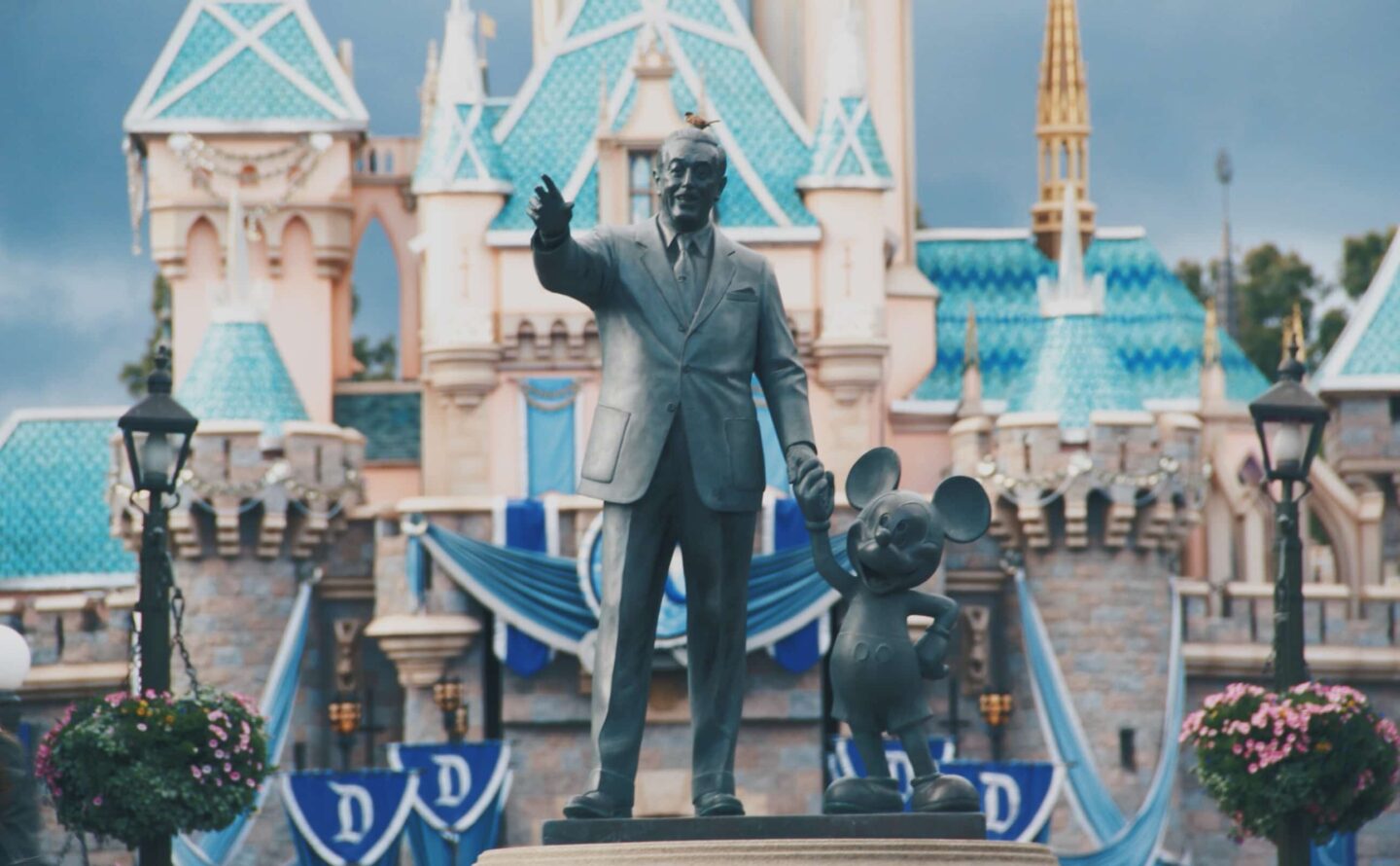 Statue of Walt Disney holding the hand of Mickey Mouse outside of Disney's Magic Kingdom.
