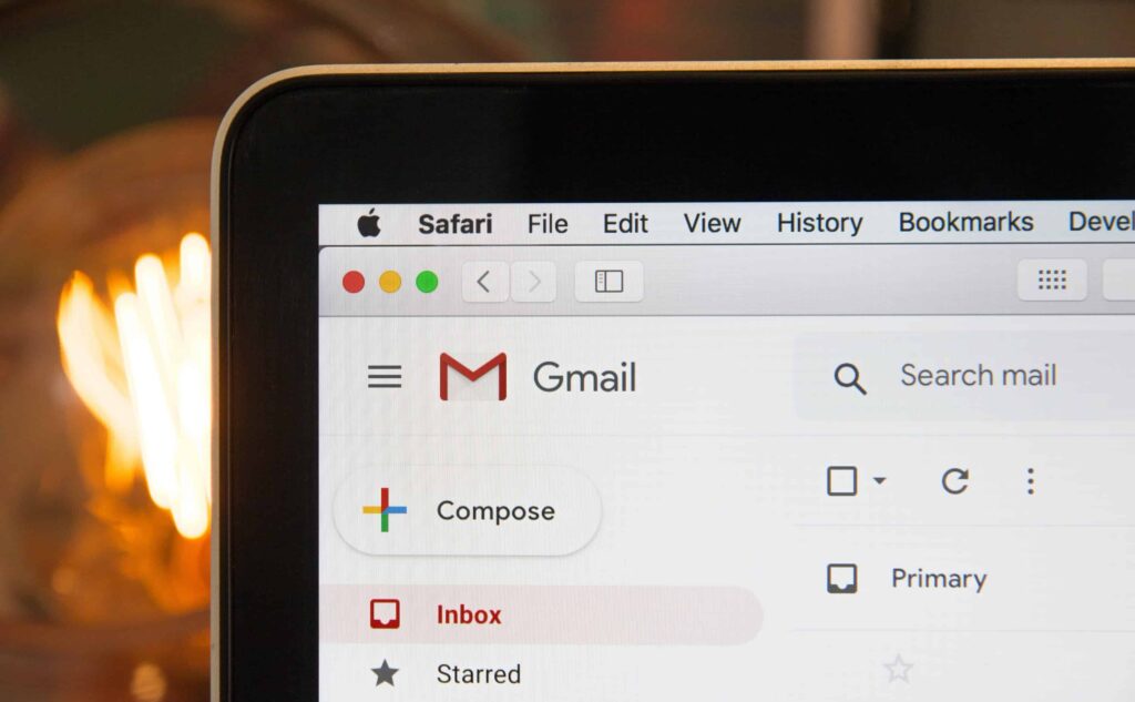 Closeup photo of a laptop viewing Gmail in front of a fireplace.
