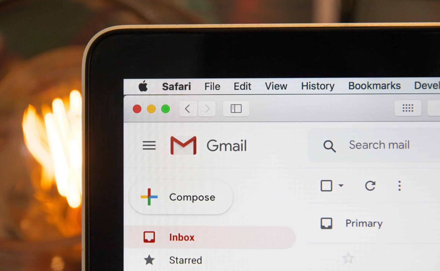Closeup photo of a laptop viewing Gmail in front of a fireplace.