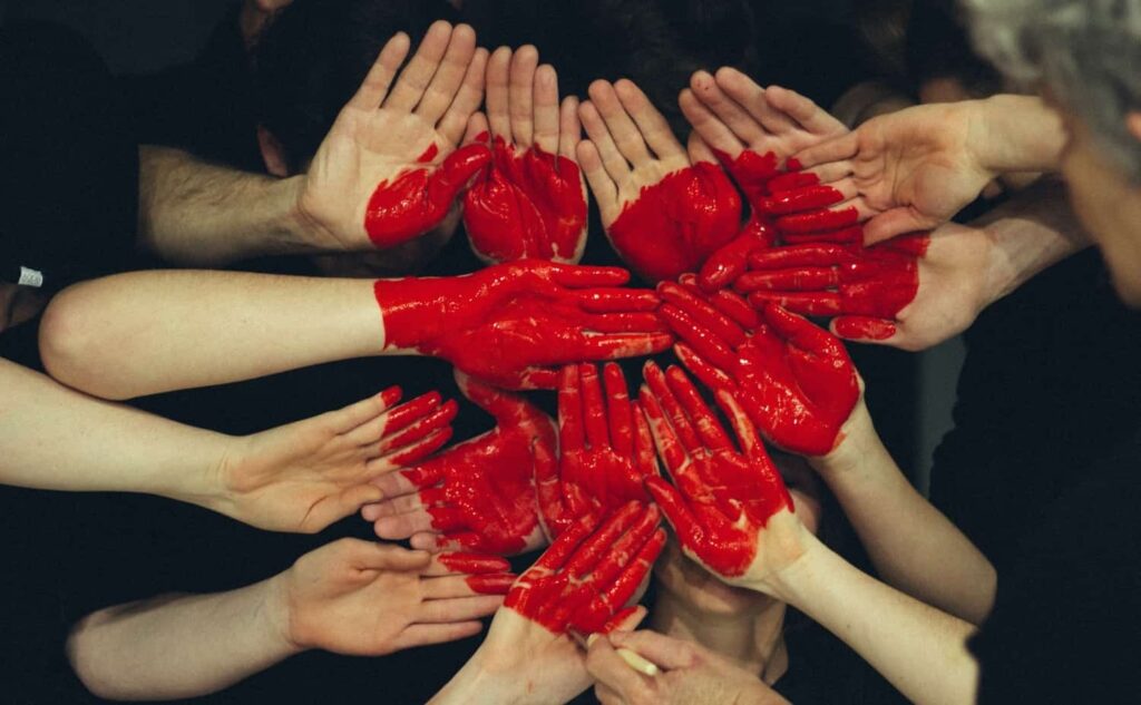 Hands together painted as a red heart to represent togetherness.